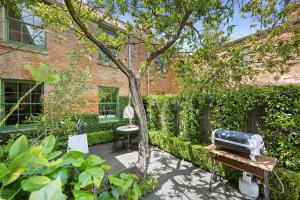 een tuin met een grill op een bankje naast een gebouw bij Gable House Geelong in Geelong