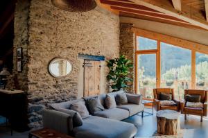 Una sala de estar con un sofá y una pared de piedra. en Espectacular Chalet de Montaña Pirineos, Burg, en Burg