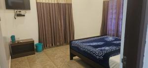 a bedroom with a bed and a television in a room at Munnar 4 bedrooms family villa in Munnar