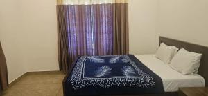 a bedroom with a bed with a blue and white blanket at Munnar 4 bedrooms family villa in Munnar