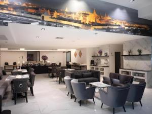 a restaurant with couches and tables and chairs at Iconic Hotel in Bangkok