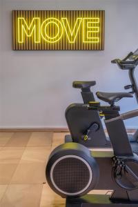 a gym with a exercise bike and the m gym sign at Hyatt Centric Reims in Reims