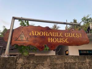 an adoptable guest house sign in front of a building at Adorable Guest House in Midigama East
