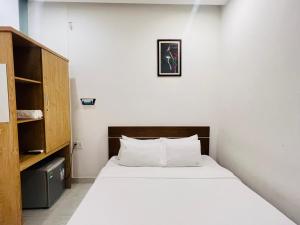 a bedroom with a bed and a picture on the wall at Bona Hostel in Da Nang