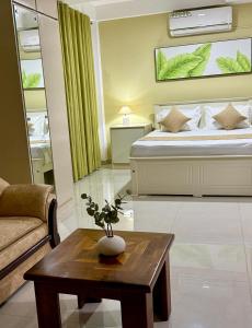a bedroom with a bed and a table with a couch at Opal Heights in Gampaha