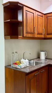 a kitchen counter with a sink and wooden cabinets at Opal Heights in Gampaha