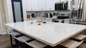 a kitchen with a large white island with chairs at 200 Steps to Beach Private Pool 2 Big Levels apts in South Padre Island