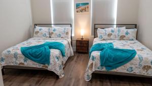 two beds sitting next to each other in a bedroom at 200 Steps to Beach Private Pool 2 Big Levels apts in South Padre Island