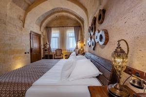 ein Schlafzimmer mit einem großen Bett in einem Zimmer in der Unterkunft Eyes Of Cappadocia Cave Hotel in Uchisar