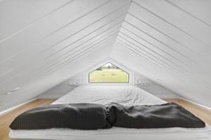 a bed in a attic with a window at First Camp Vadstena - Vättern in Vadstena