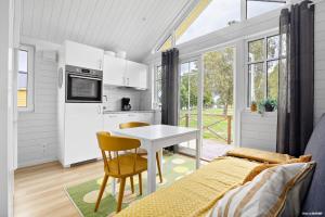 a kitchen and dining room with a table and a bed at First Camp Vadstena - Vättern in Vadstena +23 photos
