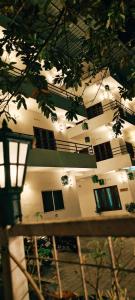 Un edificio con ventanas y un árbol en primer plano. en Oxxon Airport Hotel, en Angamaly