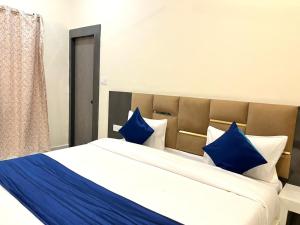 Un dormitorio con una cama grande con almohadas azules. en Hotel basant, en Orchha