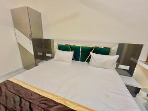 Una cama blanca grande con dos almohadas encima. en Hotel basant, en Orchha