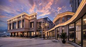 a large building with a sunset in the background at Nanjing Grand Da Qiao Hotel in Nanjing
