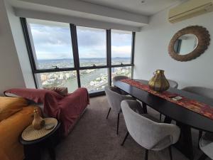 un soggiorno con tavolo e sedie e una grande finestra di Arabian Nights-Level 60-Meriton Suites- Free Parking a Brisbane