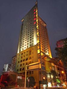 重慶市にあるChongqing Tianyou Hotelの上部に照明が付いた高い建物