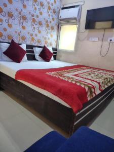 a bedroom with a large bed with a red blanket at New Gaytri Place Near by Prem Mandir in Jāmb +3 photos