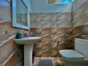 a bathroom with a sink and a toilet and a mirror at Terrace Kandy in Kandy +41 photos