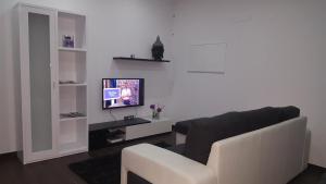 sala de estar con sofá y TV en Vivenda Paraíso, en Candelária