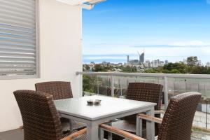 een tafel en stoelen op een balkon met uitzicht op de stad bij Hotel Chino in Brisbane