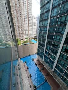 a view of a swimming pool in the middle of two tall buildings at 1BR - Uptown BGC Taguig in Manila