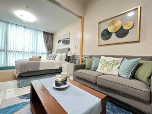 a living room with a couch and a bed at 1BR - Uptown BGC Taguig in Manila