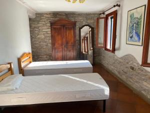 twee bedden in een kamer met een stenen muur bij Villino San Silvestro in Albettone +17 foto's
