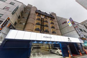 a building with a car parked in front of it at Hotel Primo Daejeon in Daejeon
