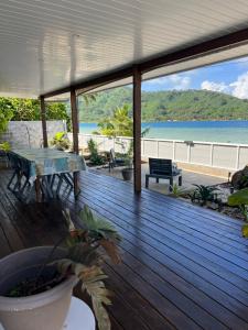 a wooden deck with a table and a view of the ocean at Blue Essence Tahaa in Tahaa