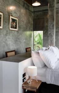 een slaapkamer met een bed en een tafel met kussens bij Nana Villa in Ko Yao Noi