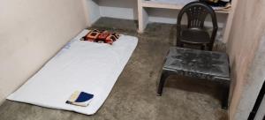 a small room with a bed and a chair at Rk home stay in Jhūsi