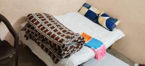a bed with a blanket on top of it at Rk home stay in Jhūsi