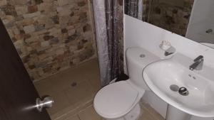 ククタにあるApartaestudio Con Amplio Parqueaderoの白いトイレと洗面台のあるバスルーム