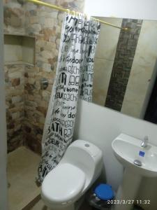 ククタにあるApartaestudio Con Amplio Parqueaderoのバスルーム(トイレ、洗面台、シャワーカーテン付)