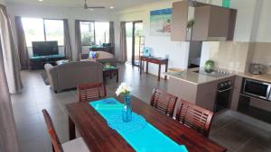 a kitchen and a living room with a table and chairs at Nautilus Apartments in Mission Beach