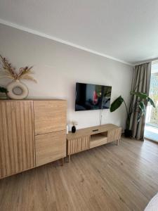 TV a/nebo společenská místnost v ubytování Modernes Seeblick Apartment mit Sauna und Poolnutzung