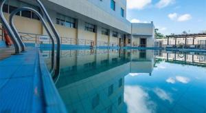 a swimming pool in front of a building at Excemon Beach Hotel Beihai in Beihai
