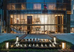 a large glass building with a bench in front of it at Huayu Zhidi Hotel in Zhongshan
