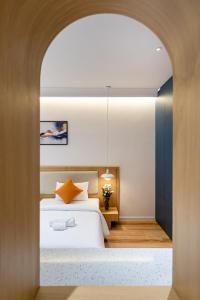 een slaapkamer met een wit bed en een boog bij APEC WANDER HOTEL - Near Tan Dinh Market in Ho Chi Minh-stad