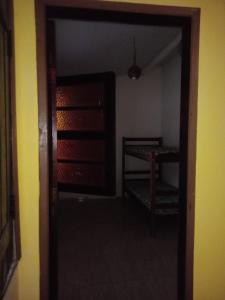 an empty room with a door and a chair at Hostel Mangabeira in Cachoeira +4 photos