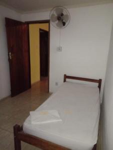 a bedroom with a bed with a fan and a door at Hostel Mangabeira in Cachoeira