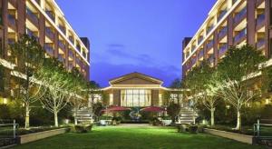 a building with a lawn in front of two buildings at Emerald Bay Hotel in Chengjiang