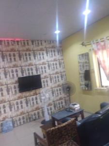 a living room with a wall covered in photographs at Ensuite in Ejigbo