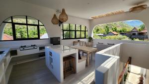 a kitchen with a table and some windows at Bnaya Villas Riverside in Amed