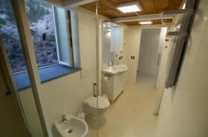 a bathroom with a toilet and a sink and a window at Maja in Ischia