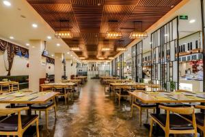 a dining room with wooden tables and chairs at Yitel Tai'an Taishan Hongmen Daimiao in Tai'an