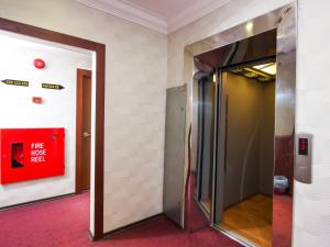 un ascensor en una habitación con una señal roja en la pared en Remember Hotel Batu Pahat, en Batu Pahat