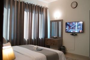 a bedroom with a bed and a television on a wall at Walk-Inn Apartments F-11 Islamabad in Islamabad