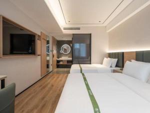ein Hotelzimmer mit zwei Betten und einem Flachbildfernseher in der Unterkunft GreenTree Inn Bengbu Huaihe Walking Street in Bengbu